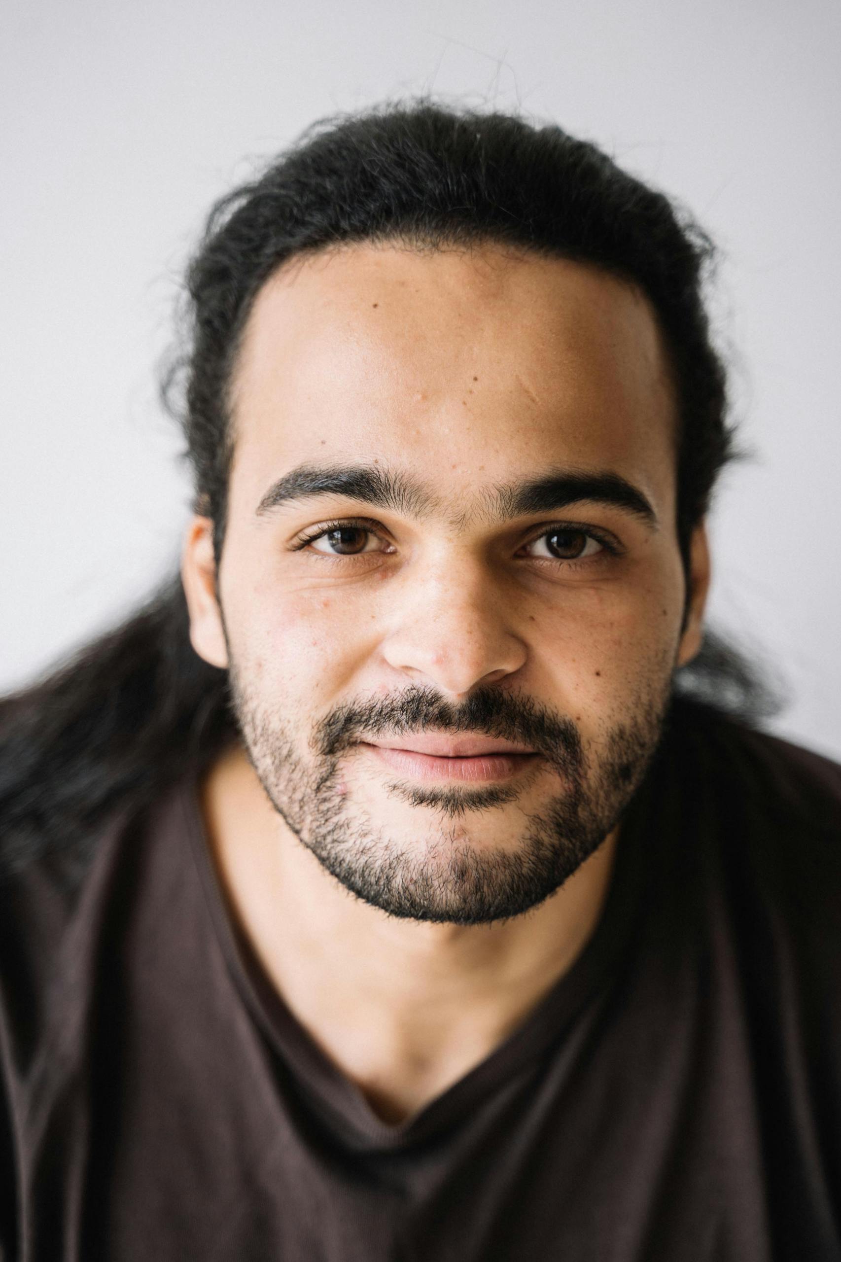 Close Up Portrait Of A Man With A Beard And Long Dark Hair Wearing A T Shirt. 5234248 Scaled